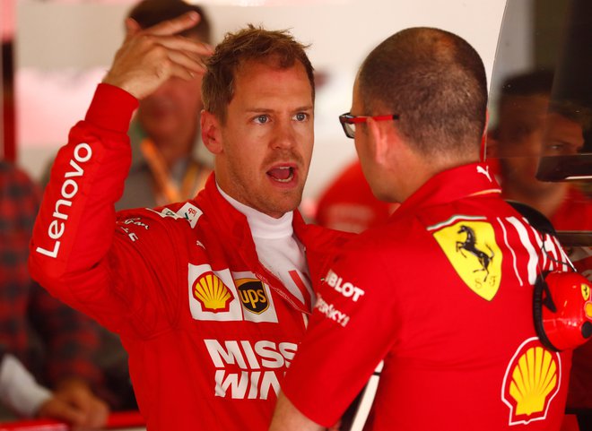 Sebastian Vettel se je med današnjim treningom posvetoval z mehaniki. FOTO: Reuters