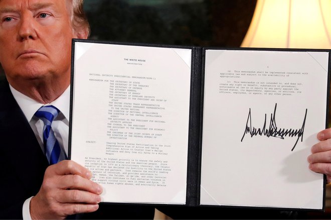 Ameriški predsednik Donald Trump v rokah drži izjavo, s katero je napovedal umik ZDA iz iranskega jedrskega dogovora. FOTO: REUTERS/Jonathan Ernst