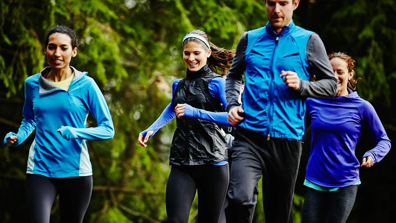Fotografija: Smiling group of friends running together on trail in park