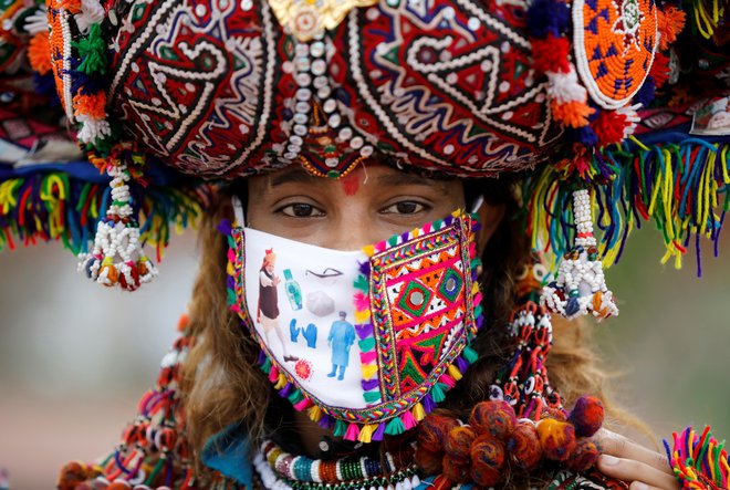 Tradicionalne obredne noše so v Indiji dopolnili z zaščitnimi maskami. FOTO: Amit Dave/Reuters