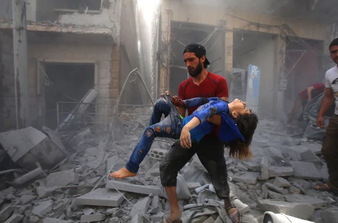 TOPSHOT - Sirec rešuje otroka iz ruševin po bombnem napadu režimskih sil in njihovih zaveznikov v sirskem mestu Maaret Al-Noman v južni pokrajini Idlib, ki je okupirano s strani džihadistov. FOTO: Abd El-aziz Qitaz/AFP
