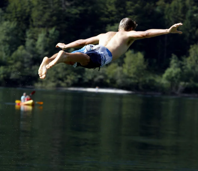 Skok v Bohinjsko jezero. Voda na kopališčih ob rekah in jezerih je bila na okoli polovici kopališč odlična. FOTO: Roman Šipić/Delo