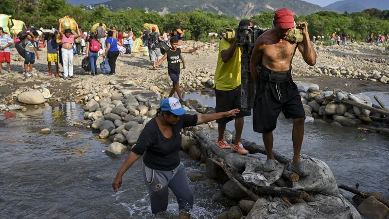 Fotografija: Prebežniki na poti v Kolumbijo. FOTO: Luis Robayo/AFP