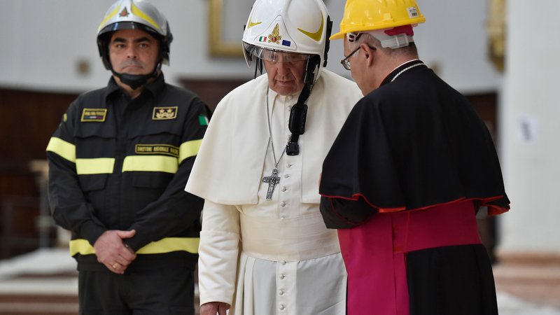 Fotografija: Papež v katedrali v italijanskem mestecu Casemino nosi varnostno čelado. Papež je obiskal območja v škofiji Camerino, ki jih je 24. avgusta 2016 prizadel potres. FOTO: Handout/AFP