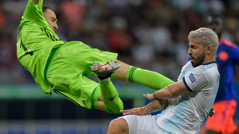 Fotografija: Na južnoameriškem nogometnem prvenstvu je v skupini B v vodstvu Kolumbija, ki je v soboto z 2:0 premagala Argentino. Na fotografiji je kolumbijski vratar David Ospina trčil v argentinskega napadalca Sergia Aguera. FOTO: Raul Arboleda/AFP