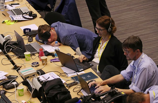 Mnogi novinarji so se odločili za vztrajanje, nekateri so zatisnili oči kar v novinarskem središču. FOTO: REUTERS