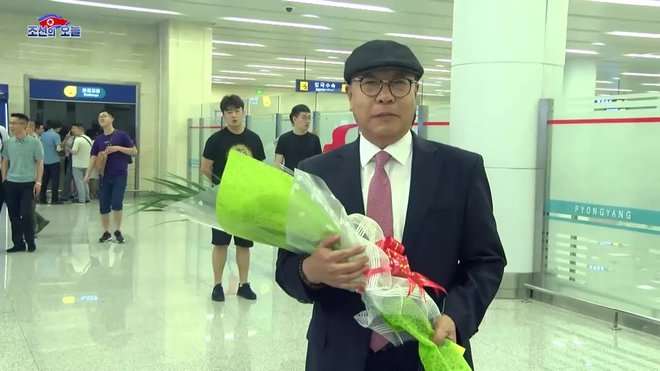 Redkega begunca so v Pjongjangu pričakali z rožami.<br />
FOTO: Youtube