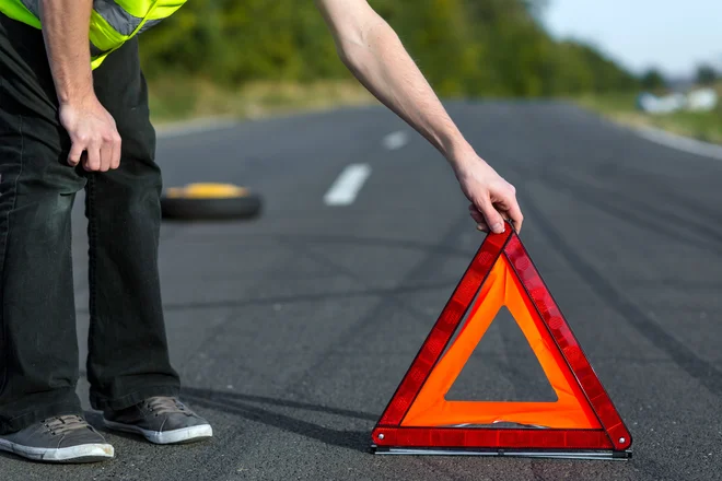 Varnostni trikotnik je treba postaviti dovolj daleč od okvarjenega avtomobila, na avtocesti vsaj 100 metrov stran. Foto Shutterstock