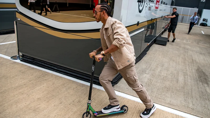 Fotografija: Lewis Hamilton se v Silverstonu zares počuti domače, po »paddocku« se je prevažal kar na skiroju. FOTO: AFP