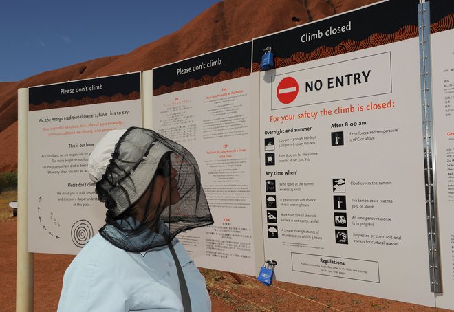 Opozorila, naj ne plezajo na Uluru, nekateri obiskovalci raje prezrejo. FOTO: AFP