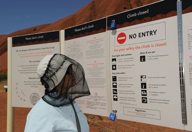 Opozorila, naj ne plezajo na Uluru, nekateri obiskovalci raje prezrejo. FOTO: AFP