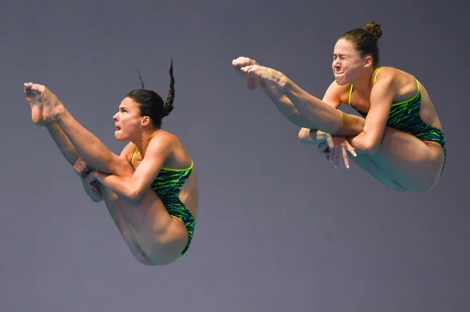 Ruski par Kristina Ilinykh in Mariia Poliakova med skokom iz trimetrske skakalne deske. FOTO: Manan Vatsyayana/AFP