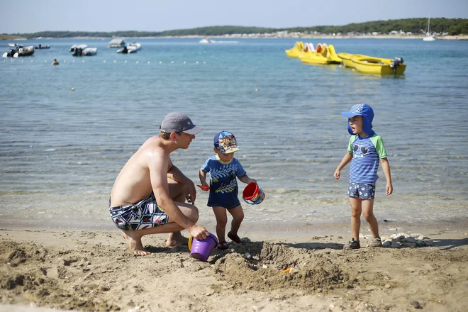 Družina Žabota pod borovci in ob morju pozabi na vsakdanje skrbi. FOTO: Leon Vidic/Delo