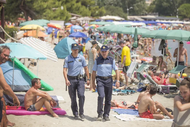 Slovenski policist Darko Grobin in hrvaški policist Josip Iliov v kampu Medulin skrbita za red. FOTO: Leon Vidic/Delo