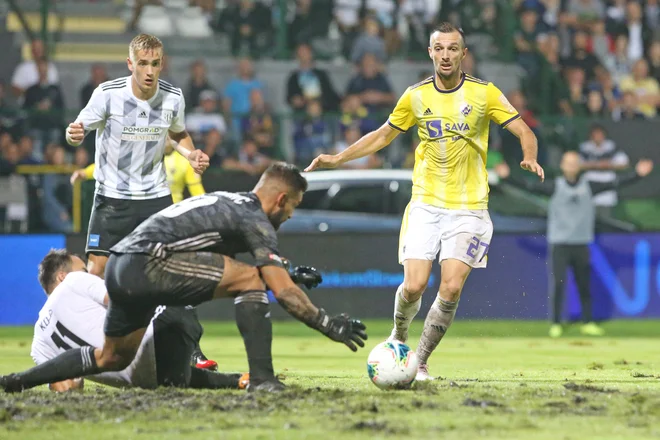 Domači vratar Matko Obradović je imel v blatu pred vrati veliko dela, ki ga je kljub prejetemu golu solidno opravil. FOTO: Tadej Regent/Delo