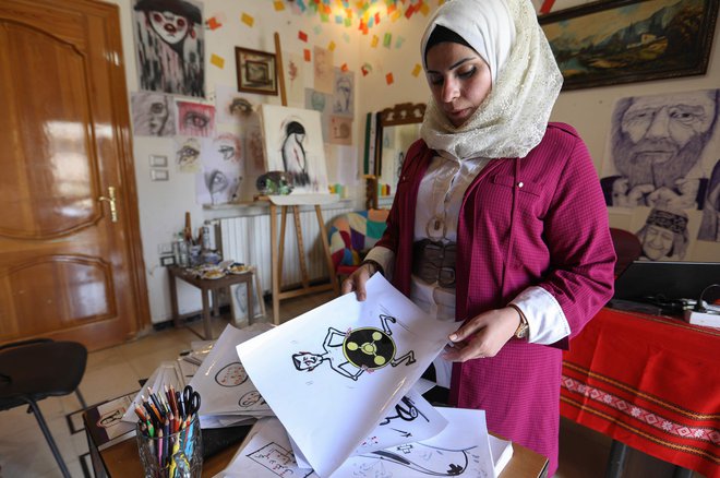 Amani al-Ali z eno svojih risb.<br />
FOTO: AFP