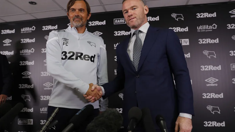 Fotografija: Wayne Rooney (desno) in trener kluba Derby County Phillip Cocu sta si takole segla v roke na novinarski konferenci ob začetku skupne poti. FOTO: AFP