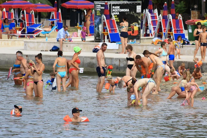 Med kopalci na portoroški mestni plaži so dopoldne prevladovale družine z majhnimi otroki. FOTO: Tomi Lombar