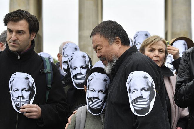 Umetnik in protestniki z maskami na shodu v podporu ustanovitelju Wikileaksa Julianu Assangeu v Berlinu maja letos. FOTO: John Macdougall/AFP