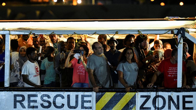 Fotografija: Sinoči je 81 migrantov, kolikor jih je še ostalo na ladji Open Arms, začutilo trdna tla pod nogami. FOTO: Guglielmo Mangiapane/Reuters
