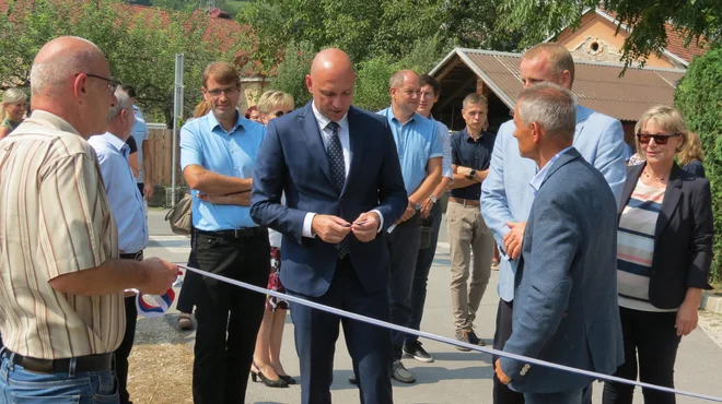 Okoljski minister Simon Zajc (na sredini) in prevaljski župan Matic Tasič sta ob zaključku prvega od šestih ukrepov v porečju Meže in Mislinje simbolično prerezala trak. FOTO: Mateja Kotnik