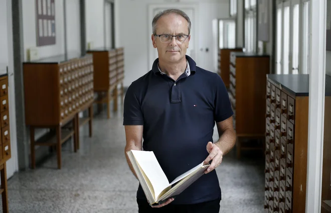 Srečko Bončina iz NUK-a s Pernkopfovim atlasom v rokah. FOTO: Blaž Samec/Delo