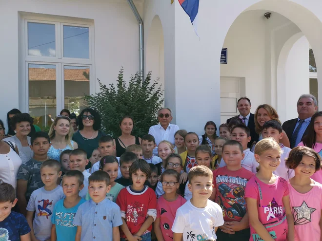 Učenci in vaščani ob odprtju prenovljene šole, mednje pomešan donator denarja za obnovo in idejni oče prenove vasi Miroslav Mišković (v zadnji vrsti). Foto Milena Zupanič