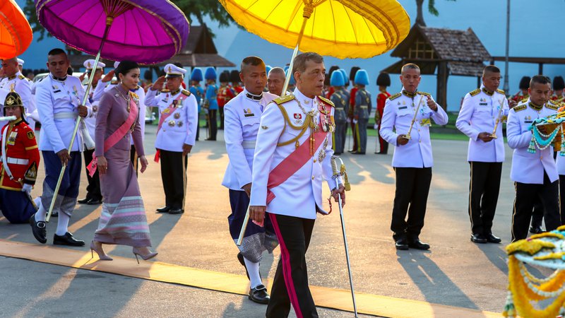 Fotografija: Nihče si ne bi drznil kralja Vadžiralongkorna (v sredini) obsoditi razvratnega življenja, se pa mnogi potiho sprašujejo, kam je izginila njegova zdaj že nekdanja konkubina, ki je hotela izpodriniti kraljico Suthido (levo). FOTO: Reuters