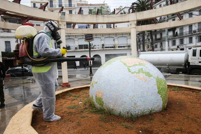 A worker wearing a protective suit disinfects a globe-shaped public garden, following the outbreak of coronavirus disease (COVID-19), in Algiers, Algeria March 23, 2020. REUTERS/Ramzi Boudina TPX IMAGES OF THE DAY