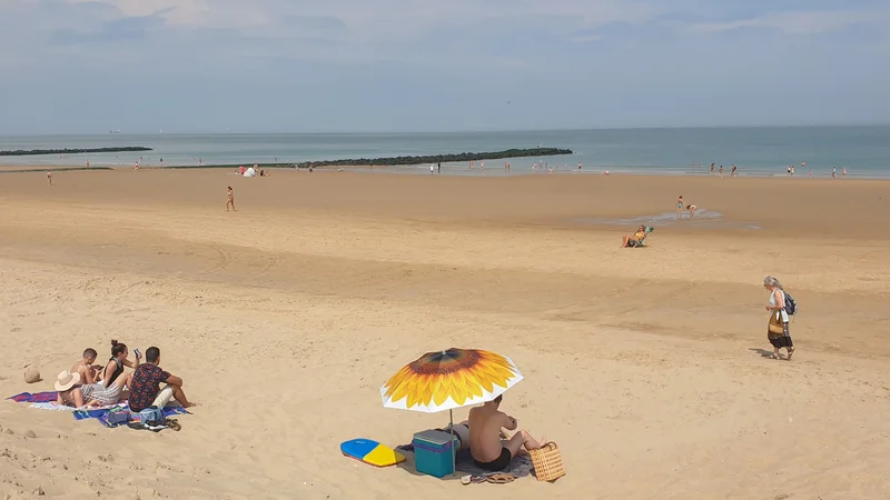 Fotografija: Redki kopalci na plaži v prestižnem belgijskem letoviškem kraju Knokke-Heist konec junija. FOTO: Clement Rossignol/Reuters