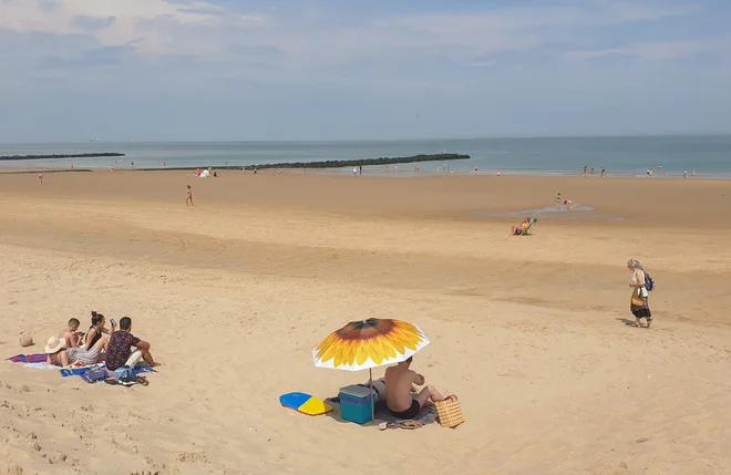 Redki kopalci na plaži v prestižnem belgijskem letoviškem kraju Knokke-Heist konec junija. FOTO: Clement Rossignol/Reuters