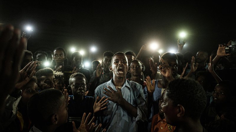 Fotografija: Letošnja zmagovalna fotografija Jasen glas prikazuje mladeniča iz Sudana, ki v Kartumu recitira protestno poezijo. Foto Jasujoši Čiba/AFP