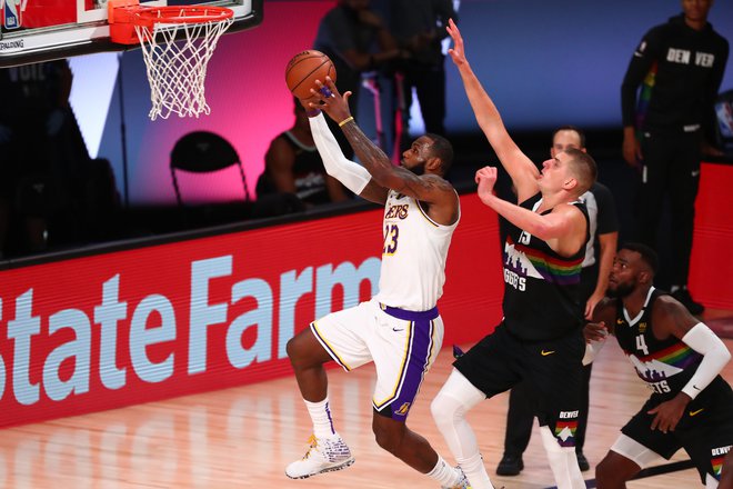 LeBron James je takole švignil mimo Nikole Jokića in dosegel koš, toda niti trojni dvojček prvega zvezdnika LA Lakers ni bil dovolj za tretjo zmago. FOTO: Kim Klement/USA Today Sports