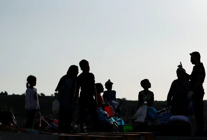 Reševanje migracijskih vprašanj na ravni EU je že nekaj let v slepi ulici. Najtežji je položaj v taboriščih na grških otokih. Na fotografiji je grški policist med pregledom ljudi na Lezbosu. FOTO: Yara Nardi/Reuters