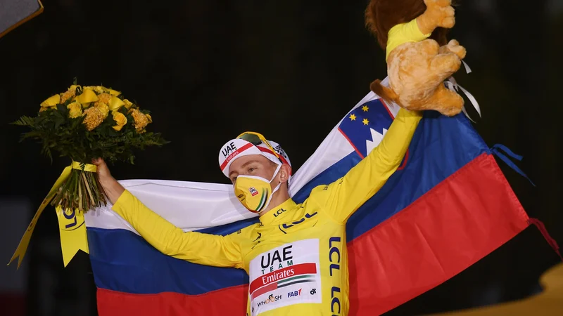 Fotografija: Tadej Pogačar je na odru za zmagovalce Toura raztegnil slovensko trobojnico. Kako bo na SP? FOTO: Marco Bertorello/AFP
