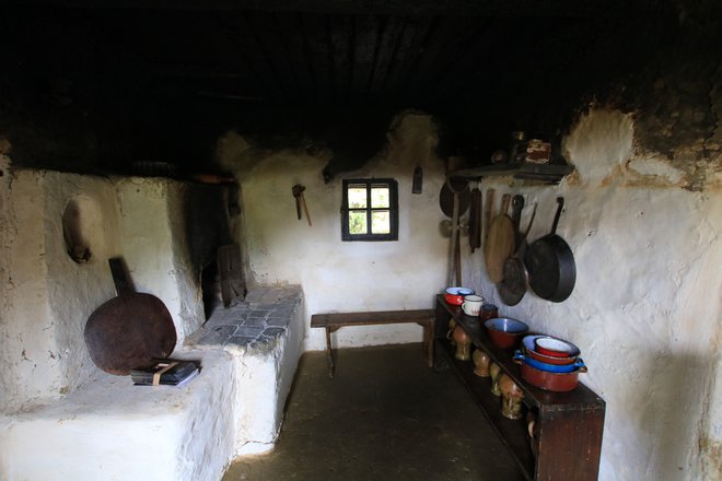 Črna kuhinja v Cilini iži je ostala takšna, kot je bila pred sto tridesetimi leti, ko je bila hiša še nova. FOTO: Jože Pojbič/Delo