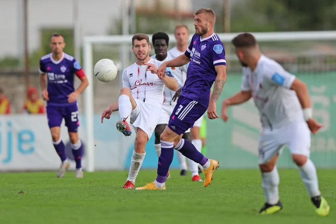 Marko Krivičić je na sredini igrišča zasenčil vijoličnega Romuna Alexandruja Cretuja in si zaslužil tudi naziv igralca 5. kola 1. SNL. FOTO: Matej Glavina