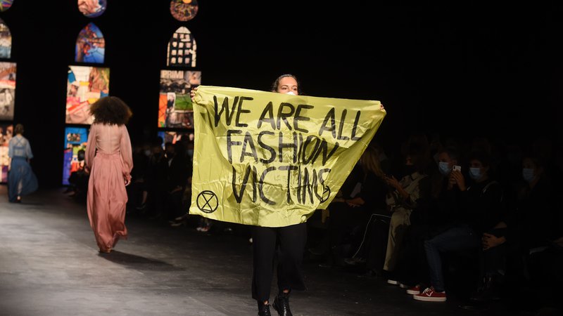 Fotografija: Med modno revijo prestižne znamke Dior, ki je potekala v okviru tedna mode v Parizu, je na pisto pritekla aktivistka z napisom »Vsi smo žrtve modne industrije.« FOTO: Lucas Barioulet/Afp

 