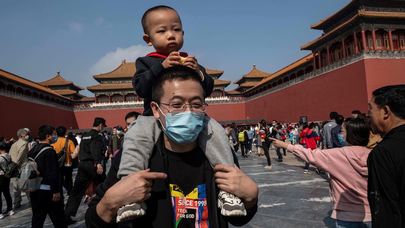 Fotografija: A boy sits on the shoulders of his father outside the Forbidden City (back) during the national day marking the 71st anniversary of the People's Republic of China and the country's national 