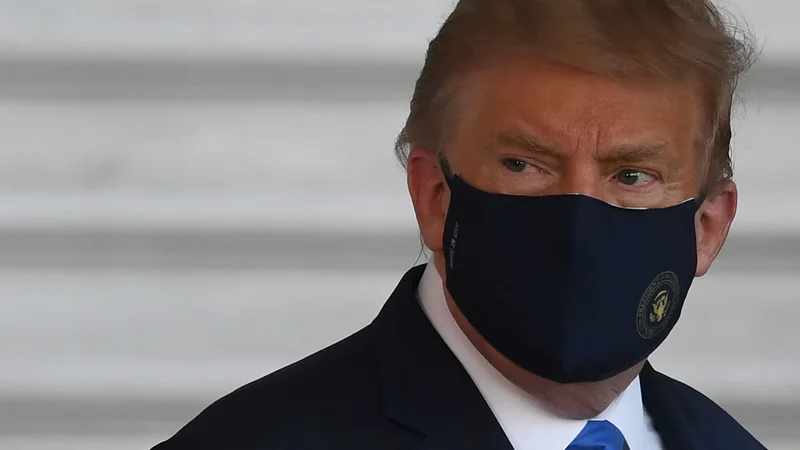 Fotografija: Donald Trump si je na poti v bolnišnico s helikopterjem Marine One nadel zaščitno masko. FOTO: Saul Loeb/AFP