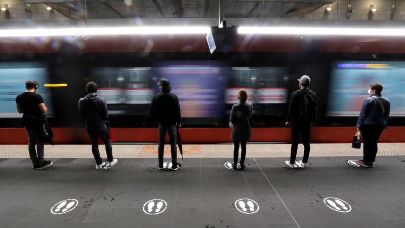 Fotografija: Varna razdalja na postaji tramvaja v Nici. FOTO: Eric Gaillard/Reuters