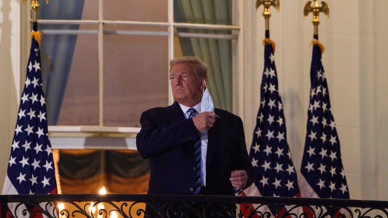 Fotografija: Predsednik Donald Trump je ob vrnitvi v Belo hišo snel zaščitno masko in covid-19 spet primerjal z gripo. Foto Nicholas Kamm/AFP