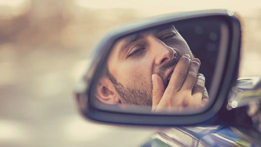 Fotografija: Side mirror view reflection sleepy tired fatigued yawning exhausted young man driving his car in traffic after long hour drive. Transportation sleep deprivation accident concept Foto Siphotography Getty Images/istockphoto