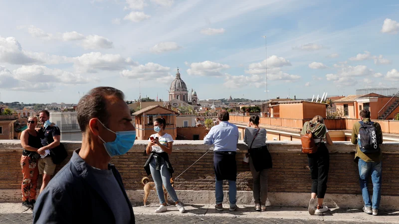 Fotografija: V Italiji so uvedli obvezno uporabo zaščitnih mask na prostem v vsej državi in zaostrili nadzor nad izvajanjem zaščitnih ukrepov. FOTO: Remo Casilli/Reuters