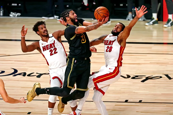 Zvezdnika Los Angeles Lakers Anthonyja Davisa sta s skupnimi močmi ustavila najučinkovitejši mož Miamija Jimmy Butler (levo) in Andre Iguodala. FOTO: Kim Klement/USA TODAY Sports