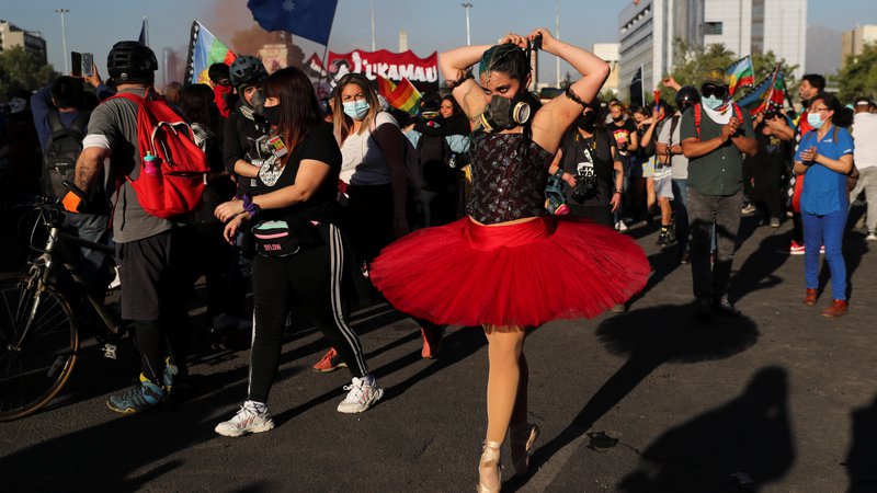 Fotografija: Balerina v plinski maski izvaja elemente baleta na demonstracijah proti čilski vladi v Santiagu de Chile. FOTO: Ivan Alvarado/Reuters