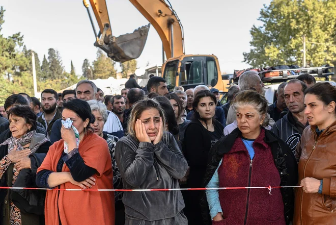 Ljudje čakajo na reševalce, da bodo izpod ruševin stavb potegnili morebitne preživele. Foto: Bulent Kilic/Afp