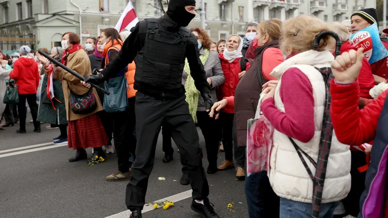 Fotografija: Beloruske upokojenke se na protestnem shodu v Minsku, na katerem zahtevajo odstop avtoritarnega voditelja in nove poštene volitve, soočajo z uslužbencem organov pregona. Beloruska policija je včeraj zagrozila, da bo proti protestnikom izstrelila prave naboje. Protesti trajajo že od sporne zmage Lukašenka na volitvah 9. avgusta. FOTO: Stringer/AFP