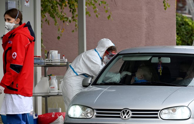 Medicinsko osebje v zaščitni obleki med testiranjem na koronavirus v Zagrebu. FOTO: Denis Lovrovic/AFP