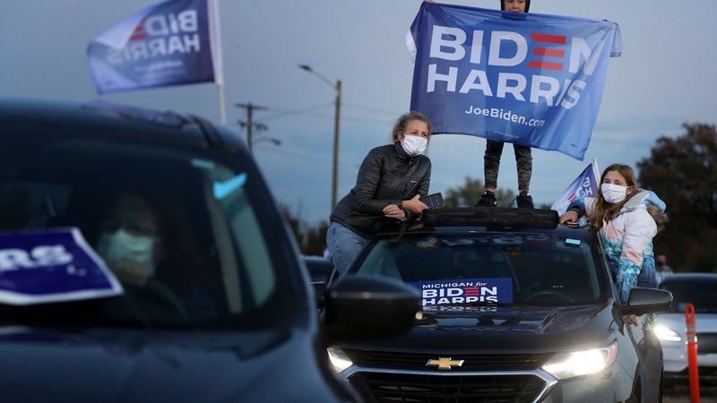 Fotografija: Prebivalci mesta Novi v zvezni državi Michigan s streh avtomobilov pozdravljajo demokratskega ­predsedniškega kandidata Joeja Bidna. FOTO: Chip Somodevilla/AFP